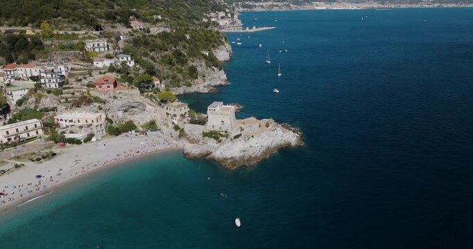 Aerial view of the vibrant Erchie beach, its ancient tower standing guard amidst the turquoise sea, a captivating coastal scene, Erchie, Amalfi Coast, Italy.