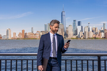 Business texting message. Online business messaging. Business man in suit use phone outdoor. Messaging businessman check email. Businessman reading message on phone in New York