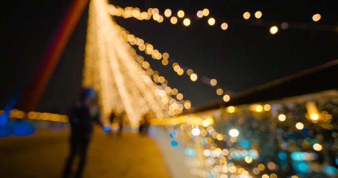 Holiday background with bridge in parck at the Christmas market. Out of focus holiday background. Light bokeh from Xmas tree. New Year theme, background.
