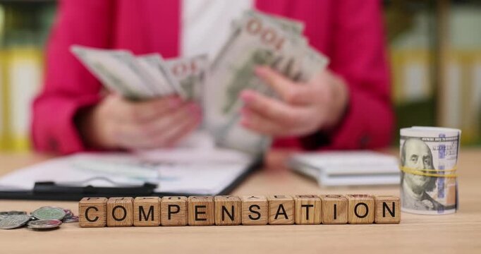 Counting cash for fair compensation while sitting at a desk with bills, coins, and important paperwork