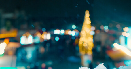 Defocused people walking through Christmas market with tree and decorations. Out of focus holiday...