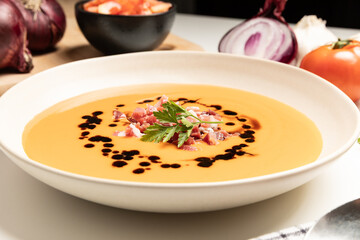 Cold tomato soup, salmorejo, served with iberico jam. Spanish traditional food.