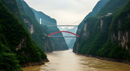 Fototapeta premium Majestic red arch bridge spanning a wide river between steep green cliffs