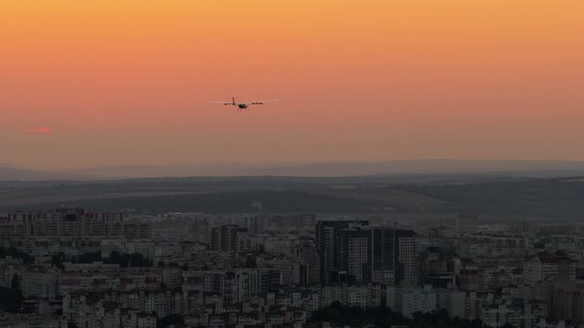 Aerial slow motion shot of fixed wing drone flying above city of chisinau at sunset with glowing horizon