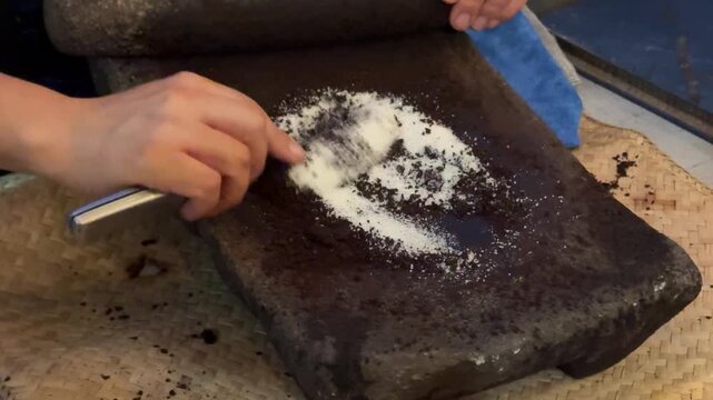 Grinding Sugar with Cacao Beans on a metate and mano to Make Chocolate in Guatemala 