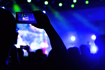People using mobile phone camera at a concert