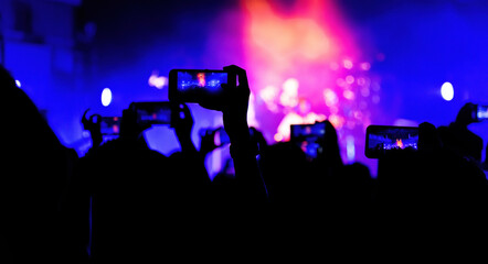 People using mobile phone camera at a concert