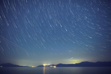 Time-lapse startrails over ocean sea waters. © astrosystem