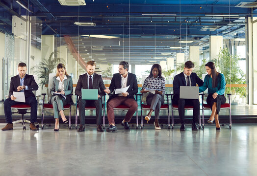 Diverse candidates sitting on chairs in row, business people applicants interns waiting for office job interview, getting ready for work, recruitment talk, employment, holding interview with candidate