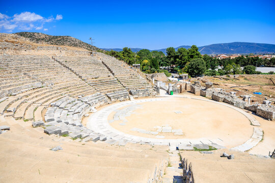 A large stone amphitheater with a stage and seating area. Ruins of the ancient city of Philippi, Greece