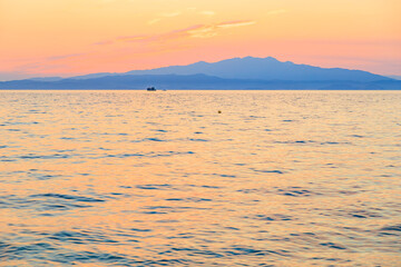 Fototapeta premium A calm ocean with a boat in the distance