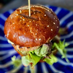Close-up of gourmet burger with lettuce and sesame bun