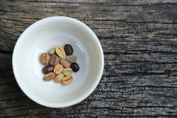 Color roast level of green coffee bean to dark roasted bean on wooden board. top view.