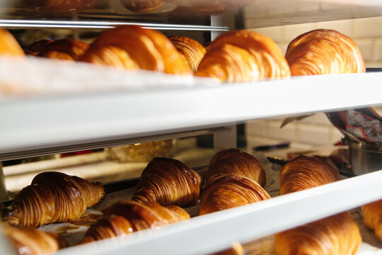 Trays of freshly baked croissants in a bakery. Bread making business - Powered by Adobe