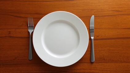 White dish and cutlery set on wooden surface demonstrating etiquette at the dining table