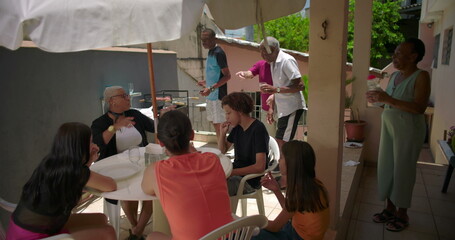 Friends organizing dinnerware on a house terrace patio, arranging a table for a casual outdoor meal and sharing tasks in a friendly atmosphere