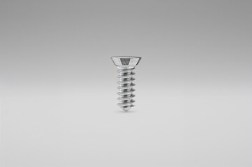 Metal screw on white textured surface, industrial and construction theme