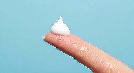 Single Finger with a Small Drop of White Skincare Cream