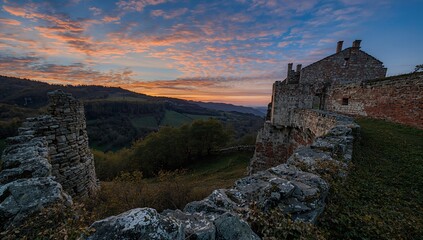 Fototapeta premium Ruins of an ancient fortress at sunset with vibrant colors, showcasing historic architecture and stone structures, perfect for travel and photography enthusiasts.