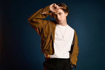 Obraz premium Young man showcases modern style with confidence in trendy outfit and striking background
