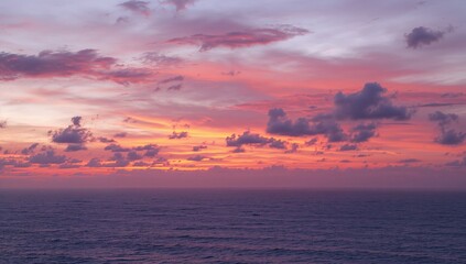 Obraz premium Ocean Horizon at Dusk with Fiery Clouds and Golden Hues