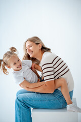 mother and child with daughter, maternal love and care, mother and child hug and kiss on a white isolated background