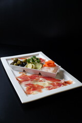 Appetizing food platter arranged in an elegant display. The dish features an array of gourmet delicacies, offering a culinary experience