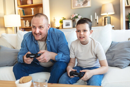 Happy father, boy and video games with controller, living room and home for bonding on weekend. Technology, esports and console for online leisure, holiday and male person for fun activity with child.