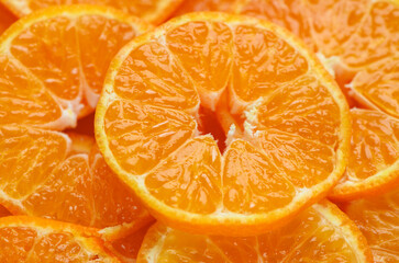 Ripe sliced mandarins close-up as background