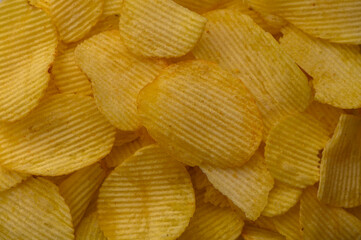 Potato chips spread on a plate as background