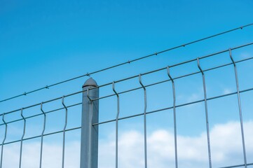 Simple Metal Wire Fence Against a Clear Blue Sky
