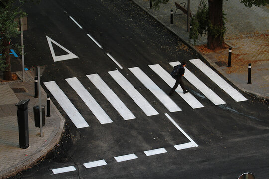 Ni&ntilde;o cruzando por paso de peatones, rayas cebra y ceda el paso por la calle hacia el colegio