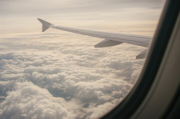 Fototapeta premium View of Aircraft Wing and Clouds from Window Seat. Aerial Perspective.