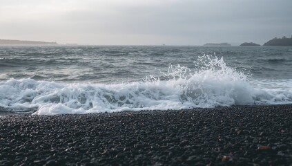 Dark pebble beach with crashing waves
