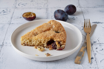 a slice of plum pie lying on a round plate, side view