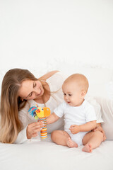 mother and baby hugging and kissing on the bed at home, maternal love and care, mother and child