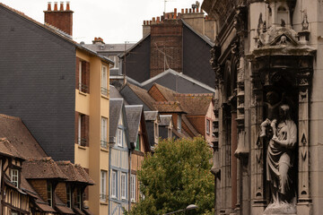 Historic street with colorful old houses and stone architecture in Rouen, France. Medieval charm and European heritage under cloudy skies, showcasing traditional urban beauty.