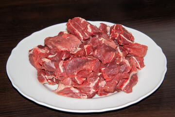 Piece of raw beef on a wooden cutting board.