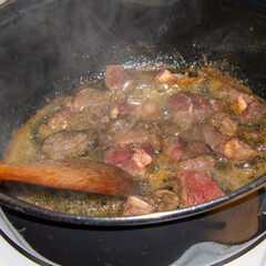 Preparing a hash with onions and stew beef.