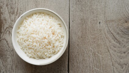 Cooked rice served in a bowl on a wooden surface, healthy and natural Asian cuisine