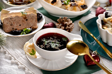 Christmas table with fraditional red borscht with dumplings and other dishes
