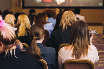 Female audience at the symposyum meeting, participants attendees in conference room hall listens to...