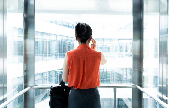 Businesswoman using mobile phone in the elevator