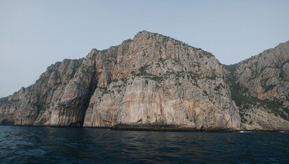 Fototapeta premium Rocky cliffs towering over the ocean, highlighting rugged coastal scenery and the untamed splendor of nature