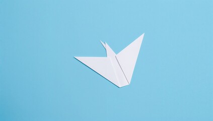 Origami white bird crafted from paper set against a blue backdrop for a global peace celebration.