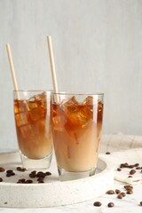 Tasty iced coffee with milk and beans on table