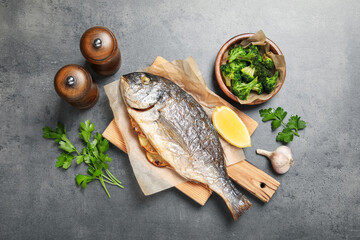 Tasty grilled fish, broccoli and spice on grey table, flat lay