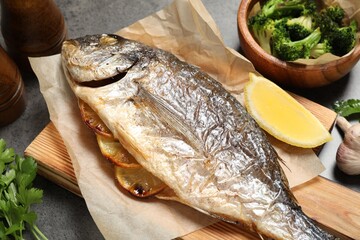 Tasty grilled fish, broccoli and spice on grey table, closeup