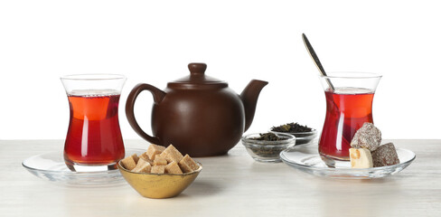 Traditional Turkish tea, delight, sugar and dry leaves on wooden table against white background