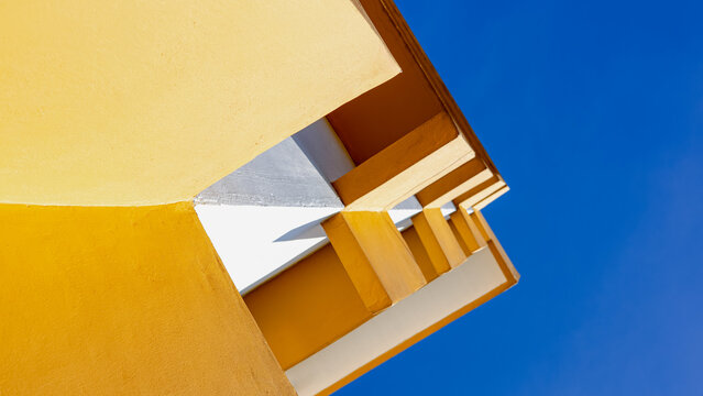 Abstract yellow building with geometric lines and blue sky perspective